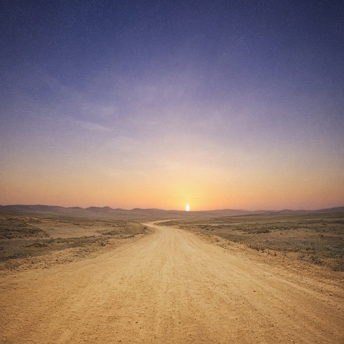 A clay road under a wide dawn sky